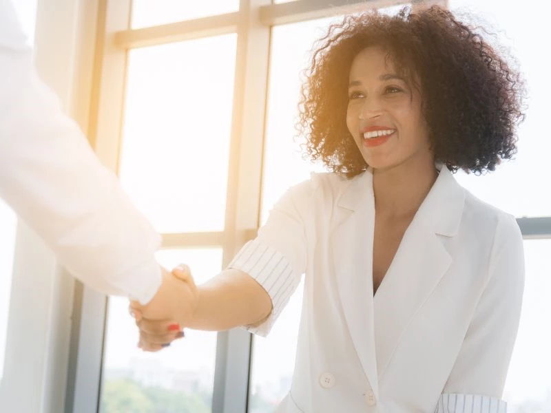 Image of a woman in professional attire shaking hands